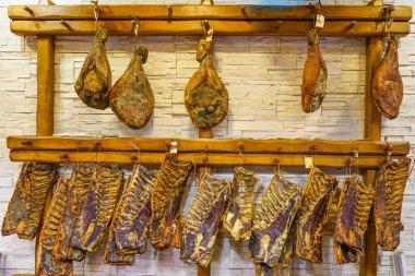 Kurutulmuş ve tütsülenmiş jambon ve kaburgalar, Avrupa 'daki küçük bir Hırvat kasabasındaki geleneksel bir kasapta asılı.