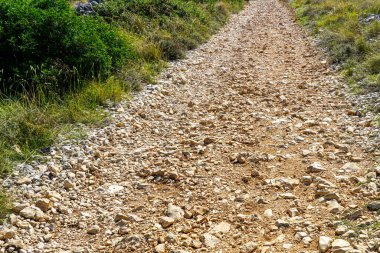 Kaba kayalık çakıl ve güneş ışığında taş yol, kırsal alanda kaba kayalık çakıl yolu, perspektif manzarası