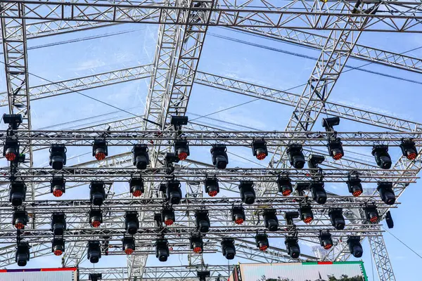 Büyük bir açık hava sahnesinin metal kirişleri ve aydınlatma elementleri, alüminyum konser sahne iskeleti parçaları, sahne ışıklandırması bir kirişe kelepçelenmiş.