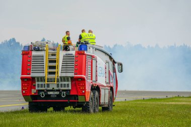 Liepaja, Letonya - 16 Haziran 2024: Havalimanı itfaiye aracı görev başında, havaalanı pistinde kırmızı modern itfaiye aracı