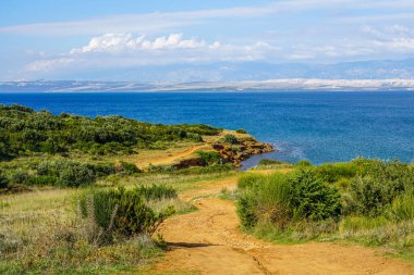 Crvenka plajı, Vir, Hırvatistan, plajın kumu etrafındaki toprağın yoğun kırmızı rengiyle boyanmış, plaj kırmızı bir kayanın altına kazınmış.
