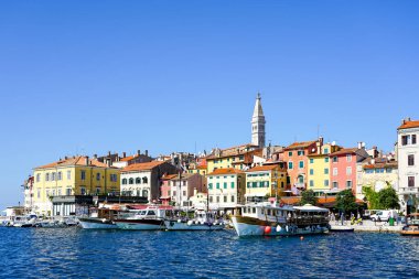 Rovinj, Hırvatistan - 25 Eylül 2024: kilise kulesi, renkli cepheler ve marinada tekneleri olan pitoresk Rovinj eski kasaba panoraması