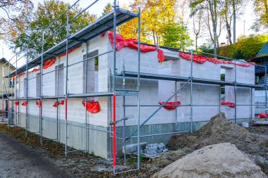 Beton temellere havalanan beton bloklardan inşa edilen yeni bir modern konut binası ön cephenin iskelesi