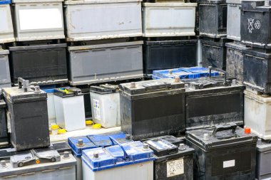 Stack of many used car batteries for recycling in a hazardous waste facility, used car batteries background clipart