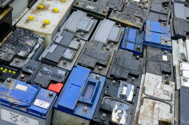 Tehlikeli bir atık tesisinde geri dönüşüm için birçok kullanılmış araba aküsü yığını, kullanılmış araba aküsü arka planı