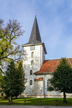 Tukums, Latvia- October 20, 2024: Tukums Lutheran Church with clay tile roof and white facade in the middle of a small town clipart