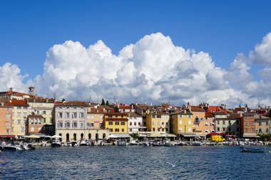 Rovinj, Hırvatistan - 25 Eylül 2024: Mavi gökyüzüne karşı tarihi evler manzaralı Rovinj limanı
