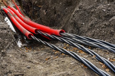 Yeni bir yeraltı yüksek gerilimli kablo döşeme kırmızı kıvrımlı koruyucu tüp Bir endüstriyel tesisin güç kaynağı için, kablo kurulumu