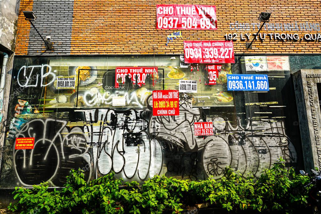 Ho Chi Minh City, Vietnam - March 16, 2025: Chaotic advertisements on an abstract wall at 192 Ly Tu Trong Street, Saigon historical center