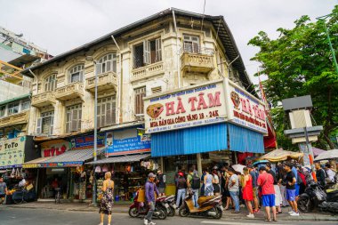 Ho Chi Minh Şehri, Vietnam- 16 Mart 2025: işlek şehir manzarası, güzel tarihi bina cephesi, Ha Tam Mücevherat, ünlü Ben Than Market 'in yanındaki altın satıcısı