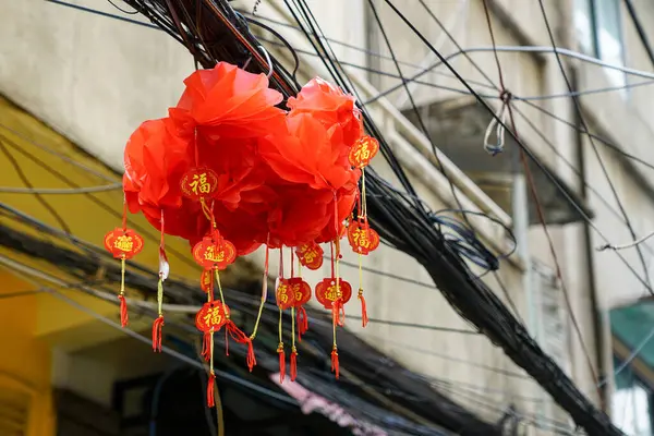 Geleneksel Çin kırmızı feneri. Eski kasabadaki kablolar arasında kutsanmış yazılar var.