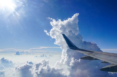 Bulutların üzerinde süzülen, Bir Uçak Penceresinden çarpıcı bir hava görüntüsü, Kule Kümülüs Bulutları, uçak kanadını gösteren, nefes kesici manzara