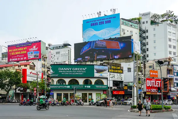 Ho Chi Minh Şehri, Vietnam - 16 Mart 2025: Ticari Bölgede Motorsikletler, Yayalar ve Renkli Billboardlarla Canlı Kavşak