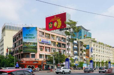 Ho Chi Minh Şehri, Vietnam-16 Mart 2025: Renkli cepheli şehir köşesi, Vietnam reklam panoları ve arka planda modern cam gökdelenler
