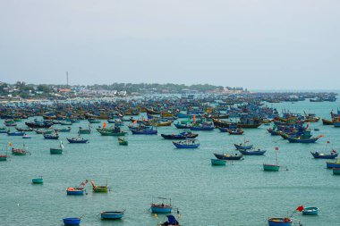 Yüzlerce canlı geleneksel balıkçı teknesinin panoramik manzarası balıkçı köyü Mui Ne yakınlarındaki bir Vietnam kıyı koyunda kalabalıktı.
