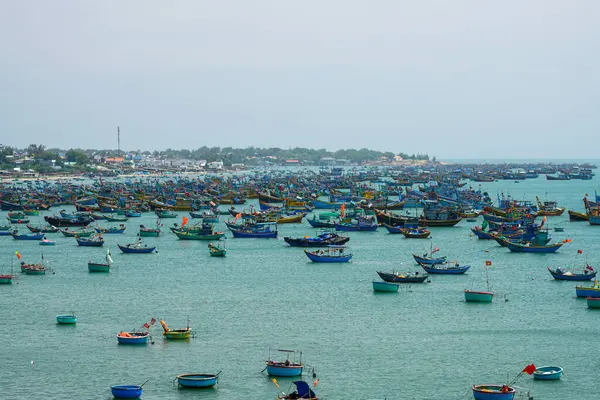 Yüzlerce canlı geleneksel balıkçı teknesinin panoramik manzarası balıkçı köyü Mui Ne yakınlarındaki bir Vietnam kıyı koyunda kalabalıktı.