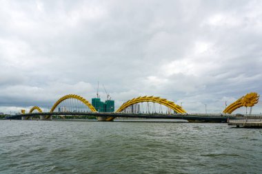 Da Nang, Vietnam-18 Mart 2025: İkonik Altın Ejder Köprüsü Vietnam 'ın Da Nang şehrinde bulunan Han Nehri' ni Urban Skyline ve Crane 'lerle geçiyor.