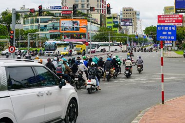 Da Nang, Vietnam-18 Mart 2025: Vietnam 'da sabah trafiği motosikletler, otobüsler, trafik ışıkları ve renkli şehir reklam panoları ile doludur.