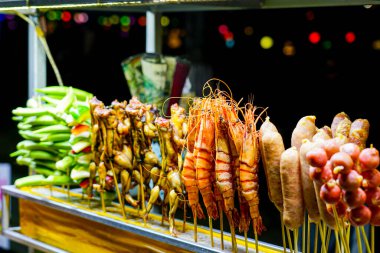 Vietnam 'da bir gece pazarında karides, sosis, kurbağa bacağı ve sebzelerin yer aldığı canlı bir dizi şiş.