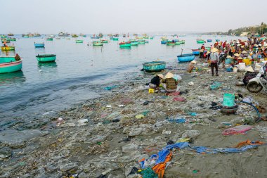 Mui Ne, Vietnam- 22 Mart 2025 Sabahın erken saatlerinde Mui Ne balık pazarında canlı ticareti ve plajı çevreleyen ağır plastik atığı ortaya çıkardı.