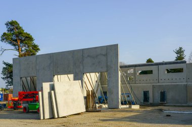 Endüstriyel İnşaat Alanına Beton Duvar Kurulumu Açık Bir günde Ağır Makineler ve İnşaat Malzemeleri Görünüşte