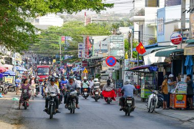 Mui Ne, Vietnam- 22 Mart 2025: Motorsikletler, yerel satıcılar, dükkanlar, tabelalar ve açık gökyüzü altında günlük yaşamın enerjisi ile dolu hareketli bir cadde