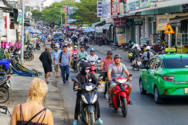 Mui Ne, Vietnam- 22 Mart 2025: Vibrant caddesi, Mui Ne, motorsikletler, taksiler ve güneşli gökyüzünün altında günlük koşuşturma