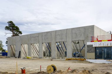 Yapısal çerçeveler, destek kirişleri ve vakıf çalışmalarının yer aldığı büyük ölçekli bir beton bina, inşaatın ilk aşamalarında yer alıyor.