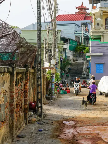 Mui Ne, Vietnam- 22 Mart 2025: Mui Ne 'de günlük hayatın scooterlarla, satıcılarla, yerlilerle ve arka planda bir tapınakla sergilendiği canlı bir sokak