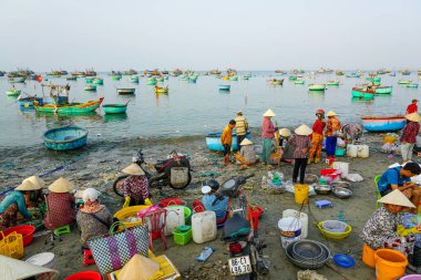 Mui Ne, Vietnam- 22 Mart 2025: Balıkçılar ve satıcılar canlı kayıklar denizinin ortasında taze balıkları satmak için Mui Ne kıyılarında toplandılar