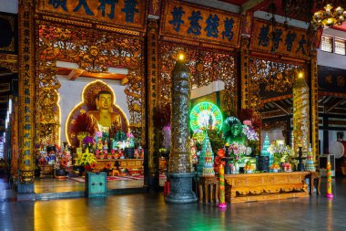 Ho Chi Minh Şehri, Vietnam- 26 Mart 2025: Vinh Nghiem Pagoda, parıldayan Buda heykeli sunak ve çiçeklerle çevrili.