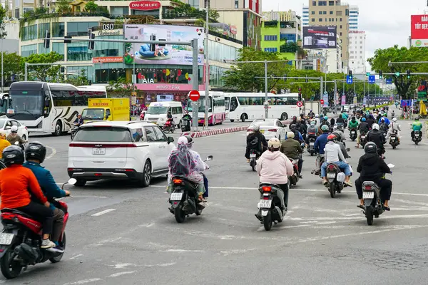 Da Nang, Vietnam-18 Mart 2025: Düzinelerce motosikletçi Da Nang 'da hareketli bir şehir kavşağında gezinerek şehrin günlük ritmini yakalıyor.