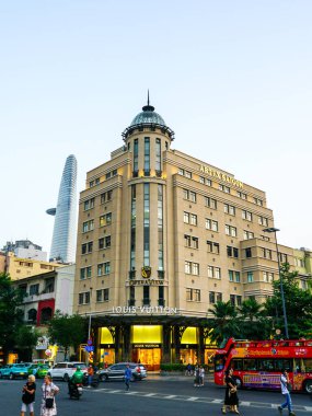 Ho Chi Minh City, Vietnam- 26 Mart 2025: Louis Vuitton mağazası, şehir trafiği ve Bitexco Kulesi olan zarif Artex Saigon binası