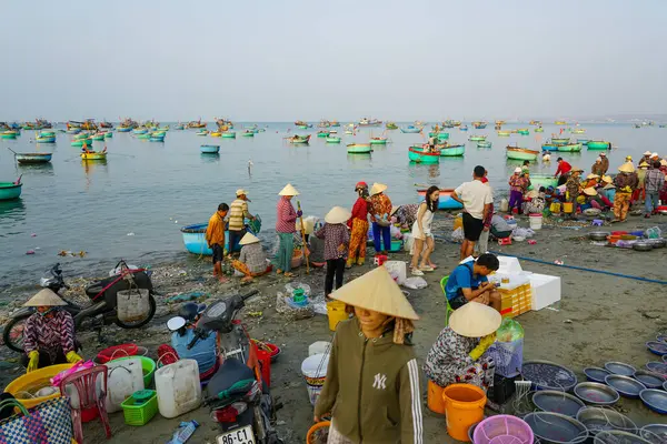 Mui Ne, Vietnam- 22 Mart 2025: Yerel halk deniz ürünleri satın almak ve satmak için sahilde toplanıyor.
