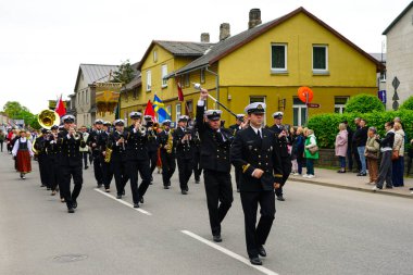Grobina, Latvia- 30 Mayıs 2025 Letonya Donanma Orkestrası, ana cadde boyunca düzenlenen Grobina Şehir Festivali geçit töreninde üniformalı bir şekilde yürüyor.