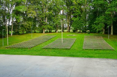 Yeşil bir parktaki açık hava sahnesindeki basit ahşap banklar açık hava konserleri, tiyatro ve toplum etkinlikleri, Letonya, Avrupa için tasarlandı.