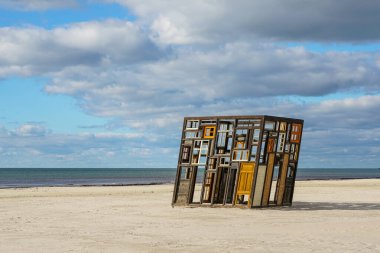 Liepaja, Letonya - 28 Eylül 2025: Baltık Denizi sahilinde sergilenen eski kapı ve pencerelerden yapılan sanat kurulumu rüzgar ve tarihi simgeliyor