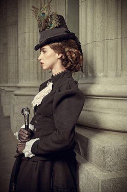 Şehir caddesinde duran zarif bir 19. yüzyıl kadını. 19. yüzyılın sonları - 20. yüzyıl başları. 