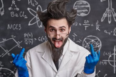 Science and education. A funny enthusiastic professor stands at the blackboard with scientific formulas sticking out his tongue and showing fuck sign. 
