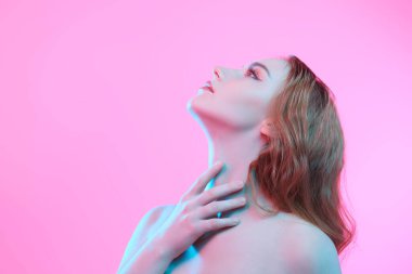 Zarif makyajlı, güzel kızıl saçlı bir kız stüdyoda, fotokopi çekilen pembe bir arka planda poz veriyor. Kadın güzelliği ve sağlığı. Kozmetik ve cilt bakımı. Güzel atış.. 