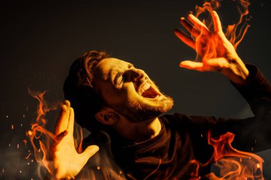 Sakallı esmer bir adam acıdan yanıyor ve acıdan bağırıyor. Karanlık bir arka planda stüdyo resmi. İnsanlar, duygular.