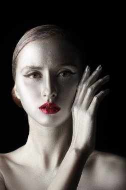 Güzellik ve kozmetik konsepti. Parlak gümüş tenli ve parlak parlak kırmızı dudaklı muhteşem bir kadın modelin sanat fotoğrafı. Moda makyajı, parıldayan dudaklar. Vücut boyama, vücut sanatı..