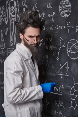 Zeki bir profesör, suratında üzgün ve şaşkın bir ifadeyle bilimsel formüller ve diyagramlarla tahtada durur. Bilim ve eğitim.