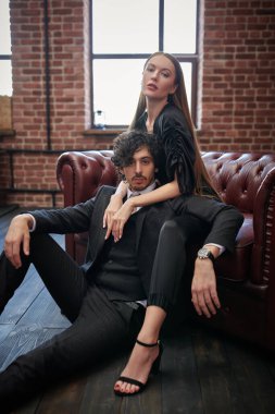 Çatı katı tarzı dairede birlikte poz veren yakışıklı bir genç adam ve zarif elbiseli güzel bir kadının portresi. Aşk konsepti. 