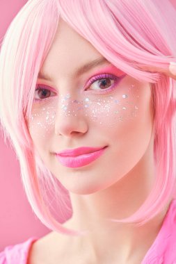 Pembe saçlı, parlak pembe çilli güzel bir kızın yakın plan portresi. Asya anime tarzı. Saç stili, kozmetik ve makyaj.