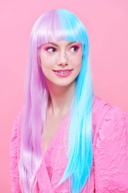 Japon animasyon tarzı. Parlak makyajlı, menekşe mavisi peruklu, şık pembe elbiseli güzel bir kız. Pembe arka planda stüdyo portresi. Moda. Saç stili, saç rengi, makyaj..