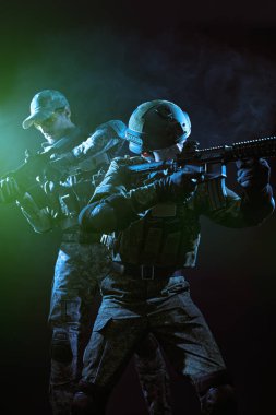 Savaş ve askeri kavram. Muharebe sırasında silahlara nişan alan Koruyucu Savaş Üniformalı cesur askerlerin portresi. Siyah bir arkaplanda stüdyo resmi.