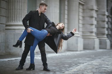 Karlı bir kış gününde keyifli bir yürüyüş. Güzel, genç ve aşık bir çift şehirde neşeyle dans ediyor. Gençler ve ilişkiler. Aşk hikayesi. Kış mevsimi. Boşluğu kopyala.