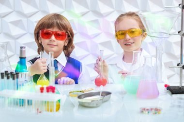 Çocukların erken gelişimi. Gözlüklü iki çocuk laboratuvarda kimyasal deneyler yapıyor. Eğitici kavram. 