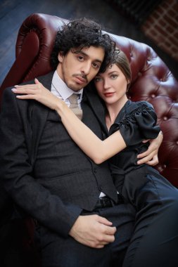Aşk konsepti. Birbirinin kollarında kanepede rahatlayan güzel bir çiftin portresi..